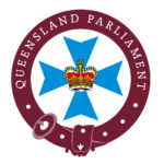 Queensland Parliament badge, a maroon circle around a blue cross with a crown in the middle
